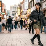 Stylish Asian woman wearing an olive green cargo skirt with black combat boots walking in Hongdae Seoul